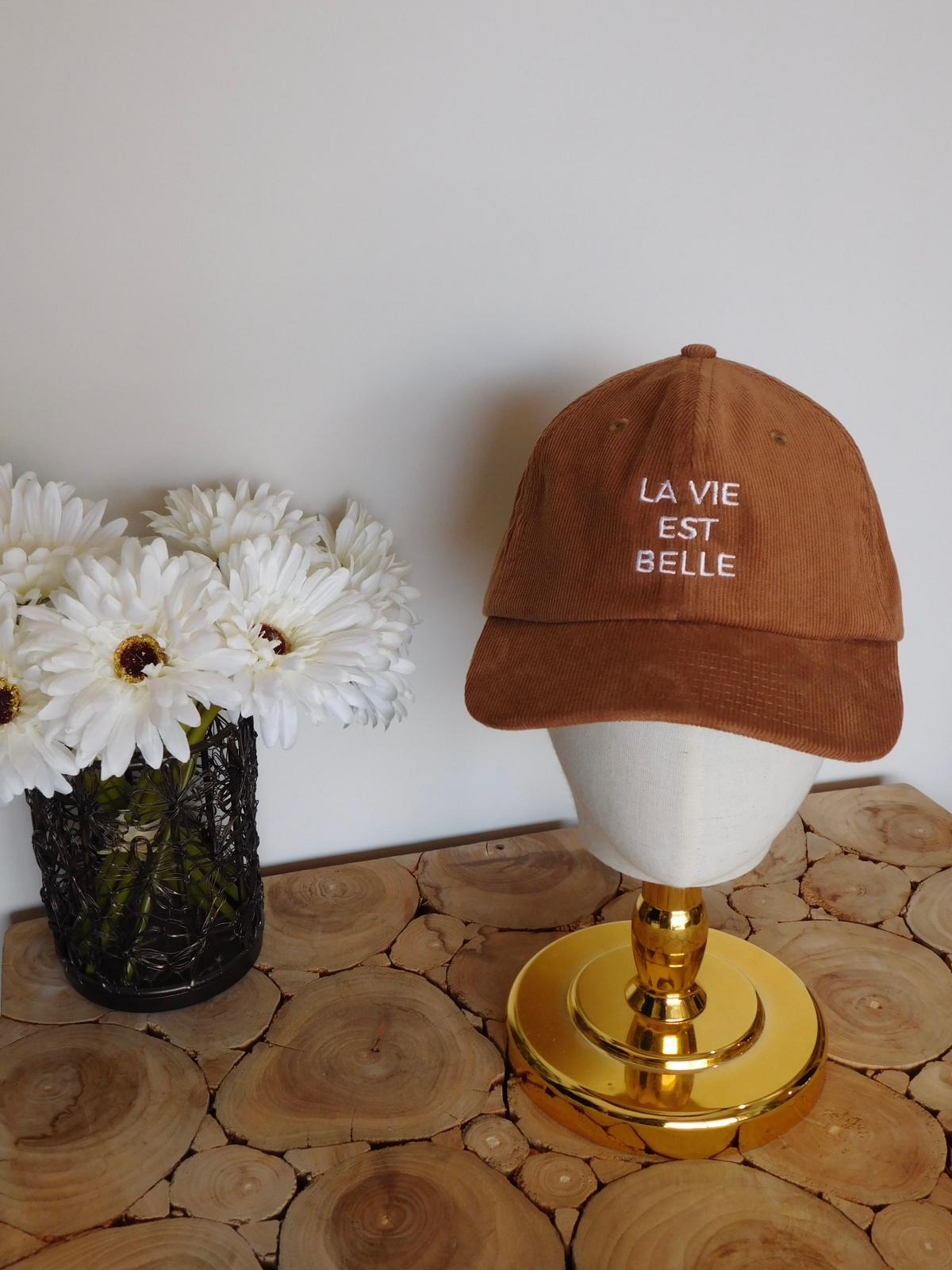 Casquette en velours côtelé camel brodée La vie est belle sur une tête de présentation dorée