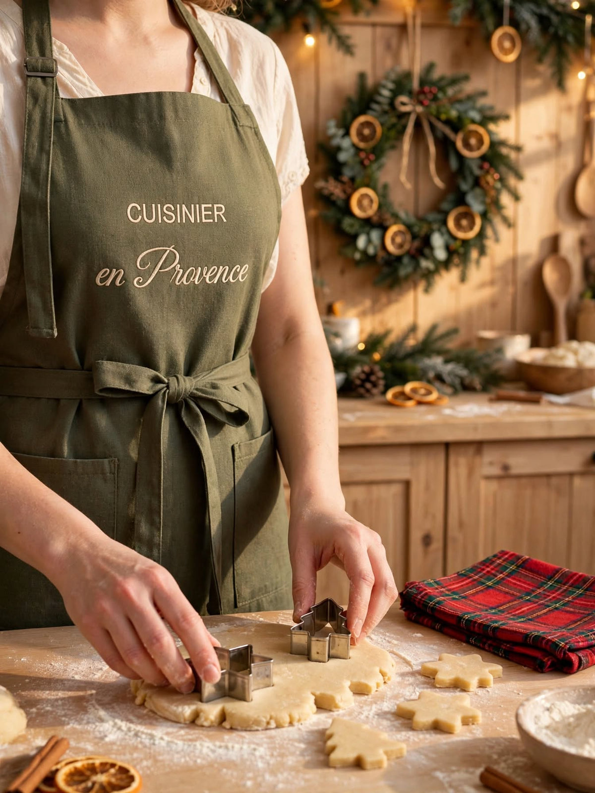 Tablier de cuisine vert olive brodé Cuisinier en Provence porté pendant la préparation de biscuits de Noël