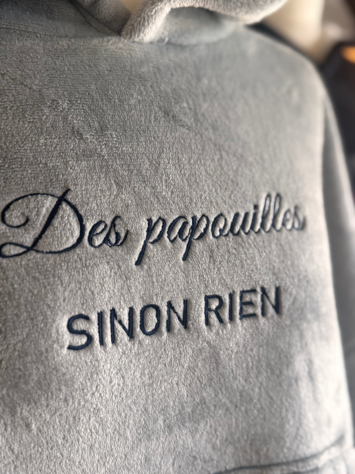 Gros plan sur la broderie Des papouilles sinon rien d’un sweat plaid gris