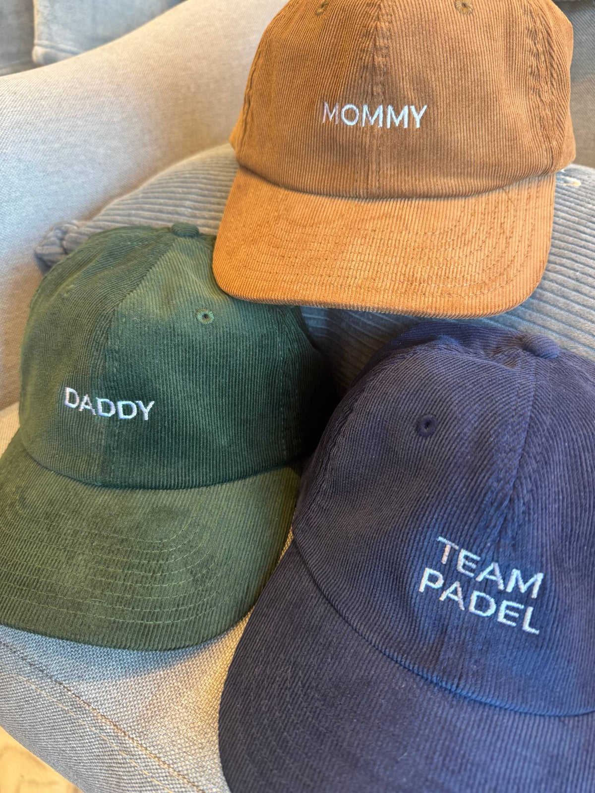 Trois casquettes en velours côtelé brodées : Mommy en marron, Daddy en vert sapin, Team Padel en bleu marine