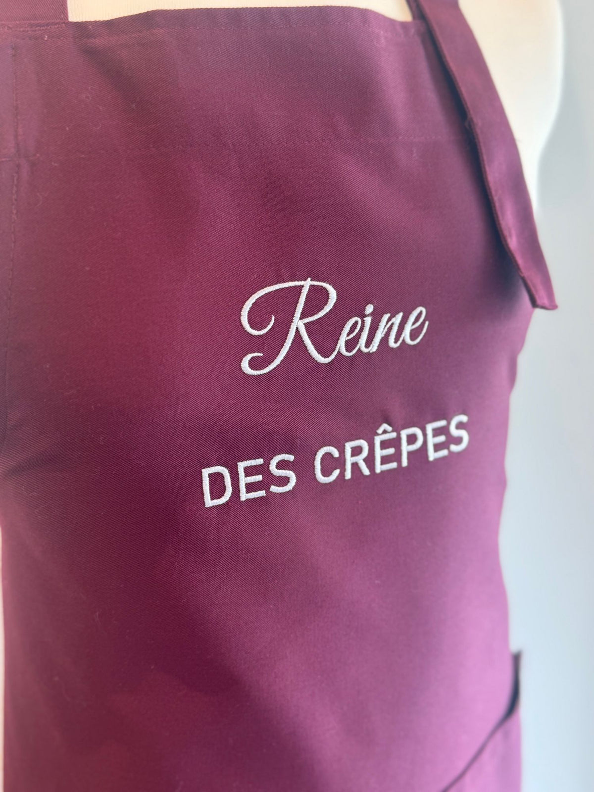Broderie blanche Reine des crêpes sur tablier bordeaux